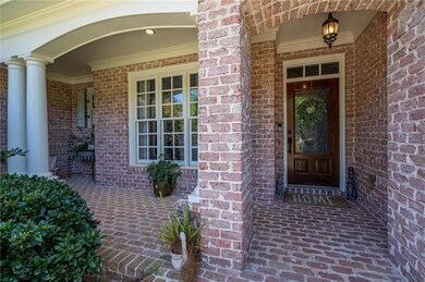 Property entrance with covered porch and brick sid