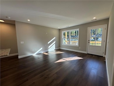 Unfurnished living room with recessed lighting and dark wood-style flooring