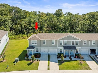 Traditional-style home featuring concrete driveway, board and batten siding, a front yard, and an attached garage