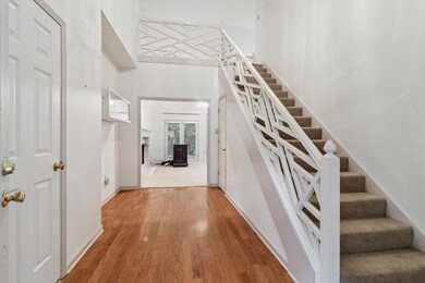Staircase featuring wood finished floors and a high ceiling