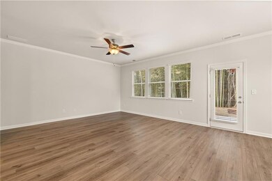 Unfurnished room featuring ornamental molding, a ceiling fan, and wood finished floors
