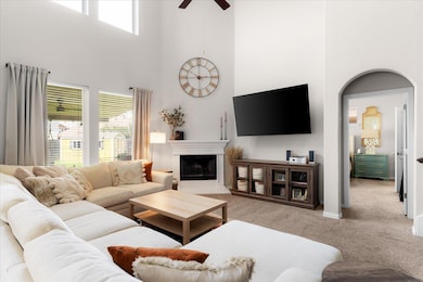 Carpeted living room with a towering ceiling, a c