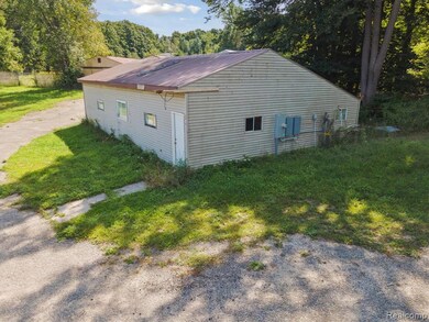 View of side of home featuring a metal roof and a yard