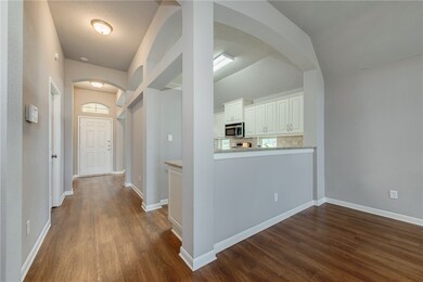 Hallway with arched walkways, dark wood-style floo