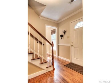 Spacious foyer features crown moulding and hardwoo