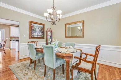 Dining room with hardwood floors, crown molding, p