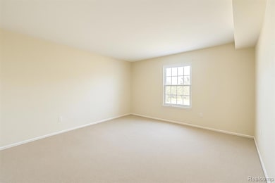 Carpeted spare room with baseboards