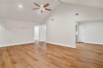 Unfurnished living room featuring ceiling fan, bea