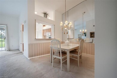 Carpeted dining area featuring a chandelier and hi