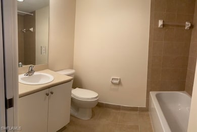 Full bathroom with baseboards, toilet, tile patter