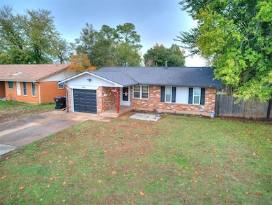 Single story home featuring a garage, brick siding, and concrete driveway