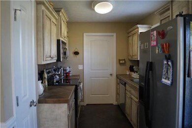 Kitchen has tile floor, tiled counter and back splash, custom glazed cabinets.