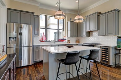 Gourmet kitchen on 2nd floor has island with Carrara marble countertop, bar seating, Restoration Hardware lighting and custom cabinetry.Other amenities include wine refrigerator, SS appliances and walk-in pantry.