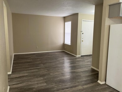 Unfurnished room with baseboards, a textured ceil