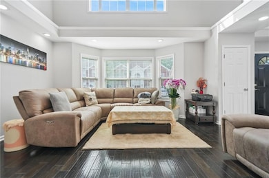 Living area with dark wood-type flooring, recessed