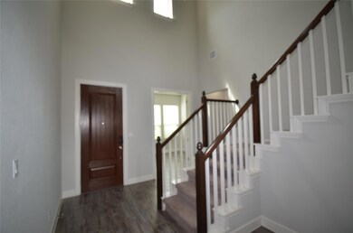 Entryway featuring a high ceiling, stairway, base