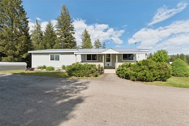 Ranch-style house with a porch and a metal roof