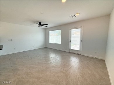Empty room with ceiling fan, light tile patterned