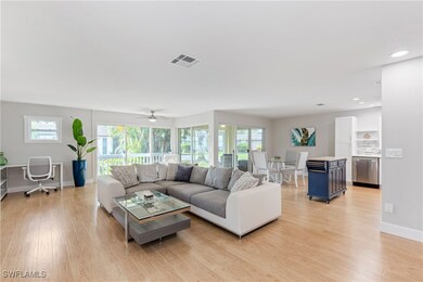 Living room featuring ceiling fan, light hardwood