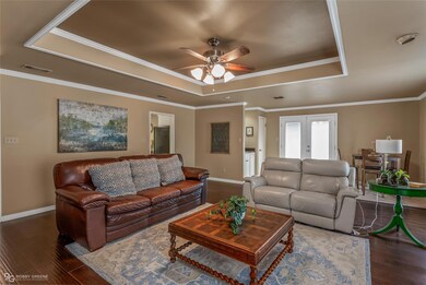 Living room featuring ceiling fan, crown molding, 