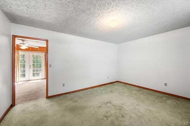Basement with concrete flooring, wood trim, and finished walls. - 5292 Java Rd, Java, VA 24565