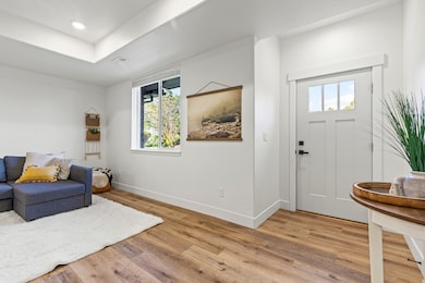 Foyer entrance with light wood finished floors and recessed lighting
