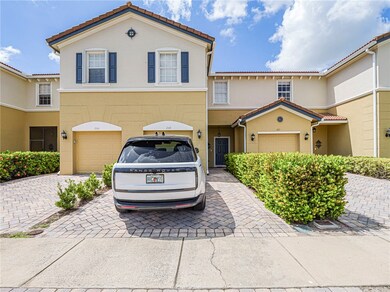 Mediterranean / spanish house with decorative driveway, a tile roof, stucco siding, and a garage