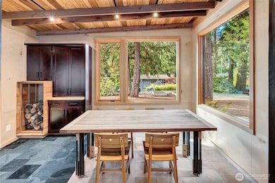 Dining room is encased in wood, stone and windows.