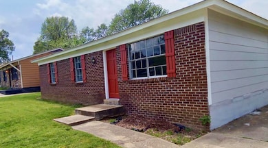 View of property exterior with a yard and brick siding