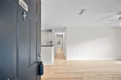 Entrance foyer featuring light wood-type flooring, a ceiling fan, and a textured ceiling
