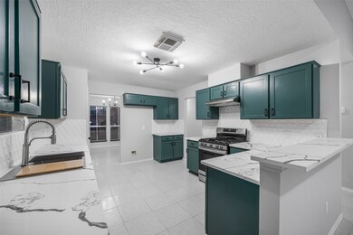 This modern kitchen features elegant teal cabinets, sleek Quartz countertops, and a stylish backsplash. It includes a high-end stainless steel gas stove and a spacious layout, making it perfect for cooking and entertaining.