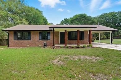 Ranch-style home with brick siding, a porch, crawl space, and driveway