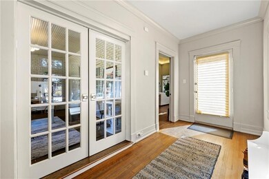 Doorway to outside with french doors, wood finished floors, and crown molding