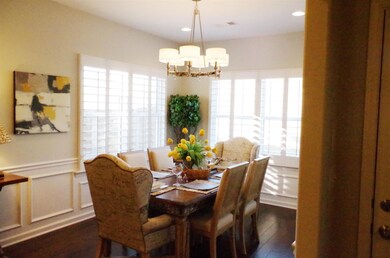 Dining area that is roomy and plenty of natural light.  This view is from the gathering room looking toward the kitchen area.  All  plantation shutters throughout home.