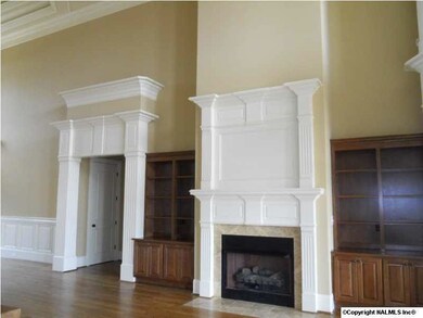 Great Room fireplace, built in bookcases, hardwood floors with panoramic view of Lake.