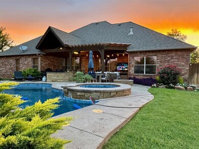 Pool at dusk with an in ground hot tub, a patio ar