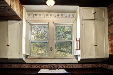 Kitchen view of a sink and dark countertops