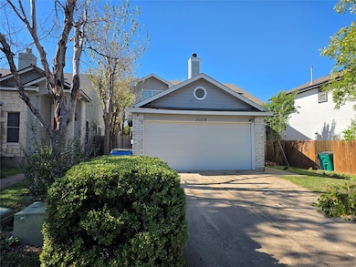 View of front of property with a chimney, concrete driveway, brick siding, and a garage