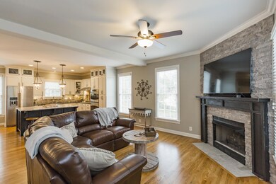 Stone hearth and fireplace make this an inviting living room- open to the kitchen, perfect for entertaining