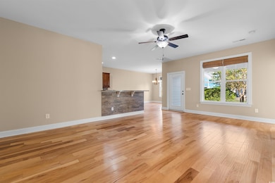 Unfurnished living room featuring ceiling fan with