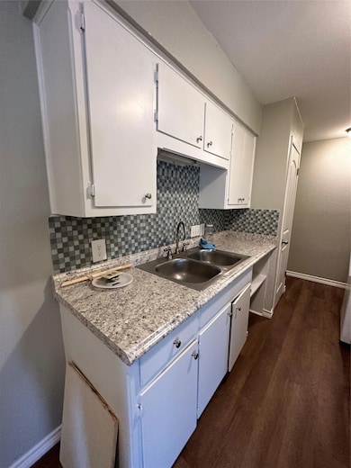 Kitchen featuring tasteful backsplash, white cabi
