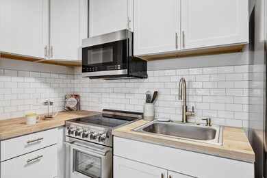 Kitchen with backsplash, a sink, stainless steel 