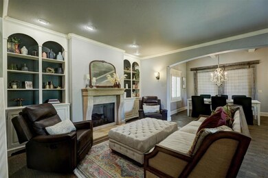 Living area featuring crown molding, arched walkwa