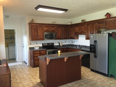 Great kitchen with lots of custom built cabinets, nice island with bar