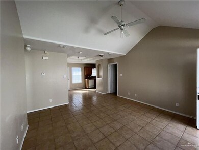 Unfurnished living room featuring ceiling fan, tile patterned flooring, and vaulted ceiling