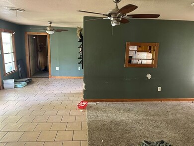 Tiled empty room featuring a textured ceiling and 