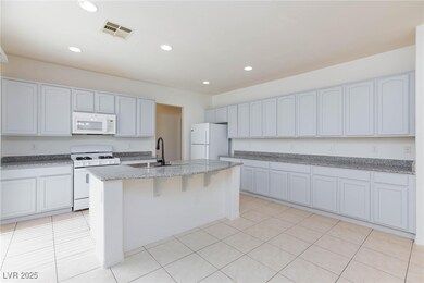 Kitchen featuring light stone counters, a sink, a