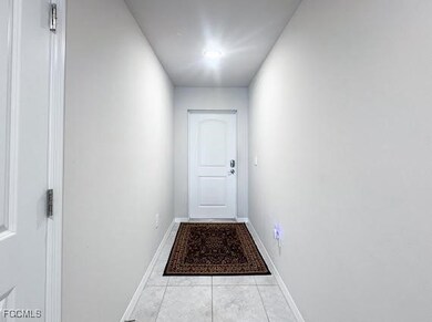 Doorway to outside with tile patterned flooring and baseboards