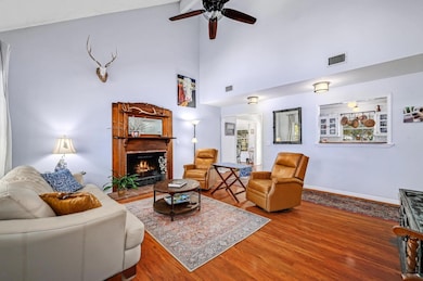 Living room featuring visible vents, a ceiling fa