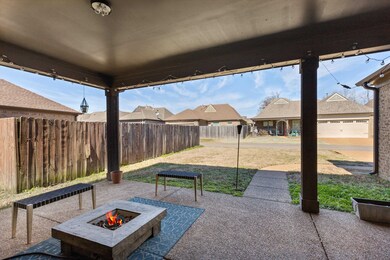 View of patio with an outdoor fire pit and fence